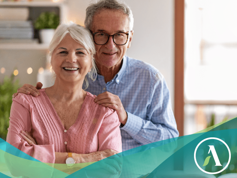 Senior caucasian couple smile at camera from a home setting.